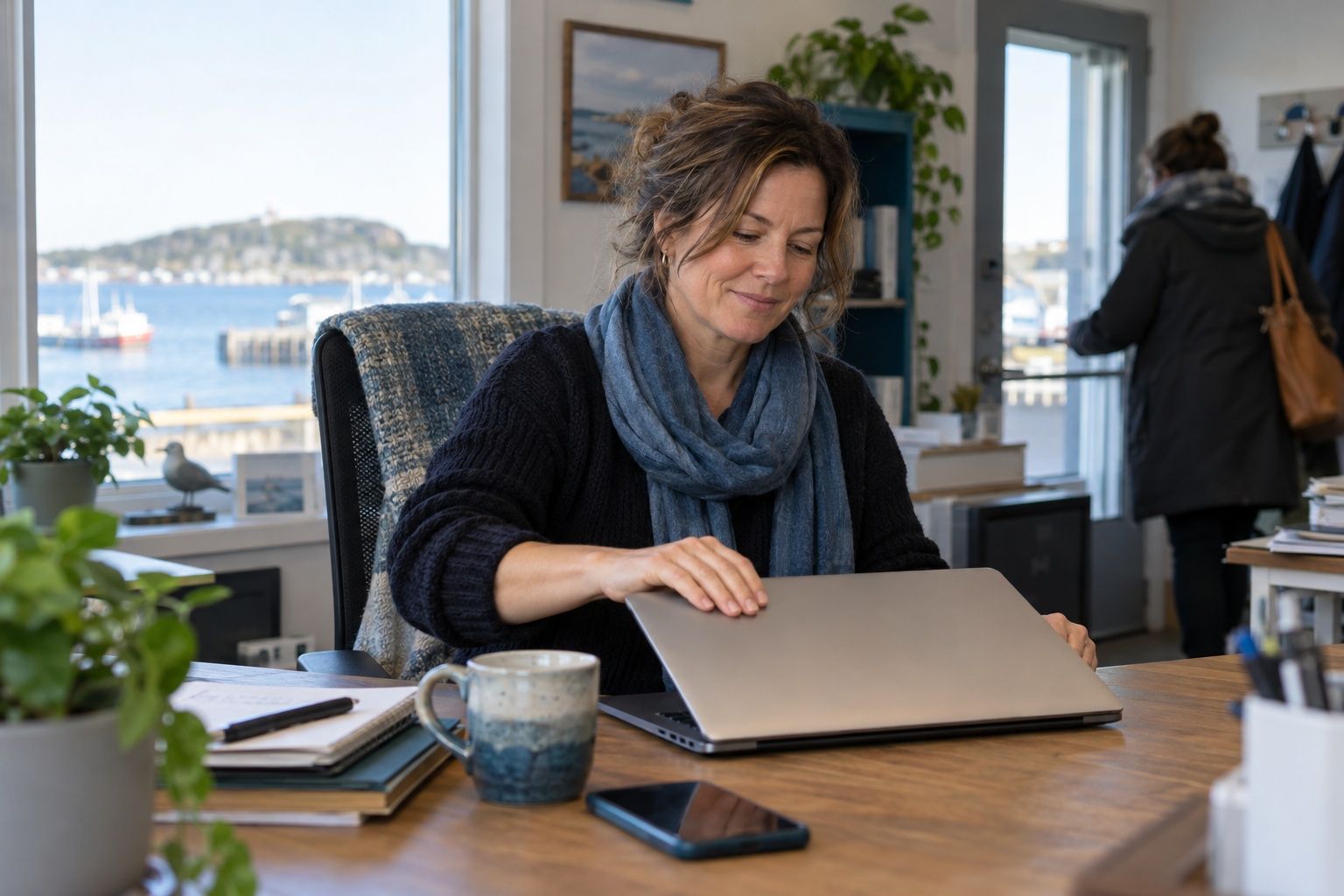 A small-business owner closing her laptop at the end of a calm workday